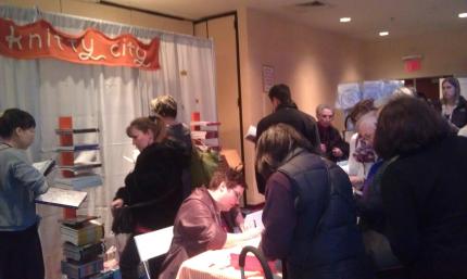 Norah signs books at the Knitty City booth.