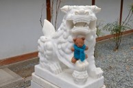 Barrison poses with a guardian lion in Kamakura.